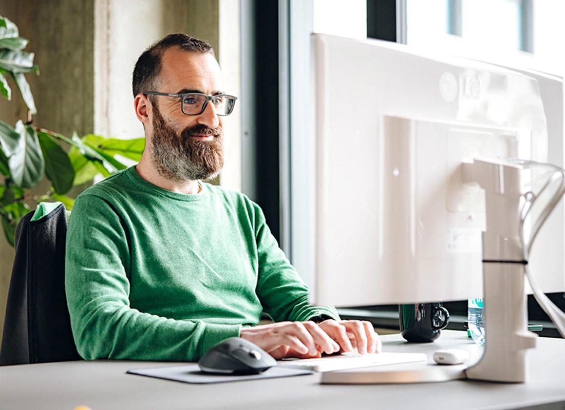 Mann sitzt am Computer und tippt