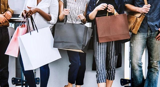 5 Personen beim Shopping mit vielen Einkaufstüten.