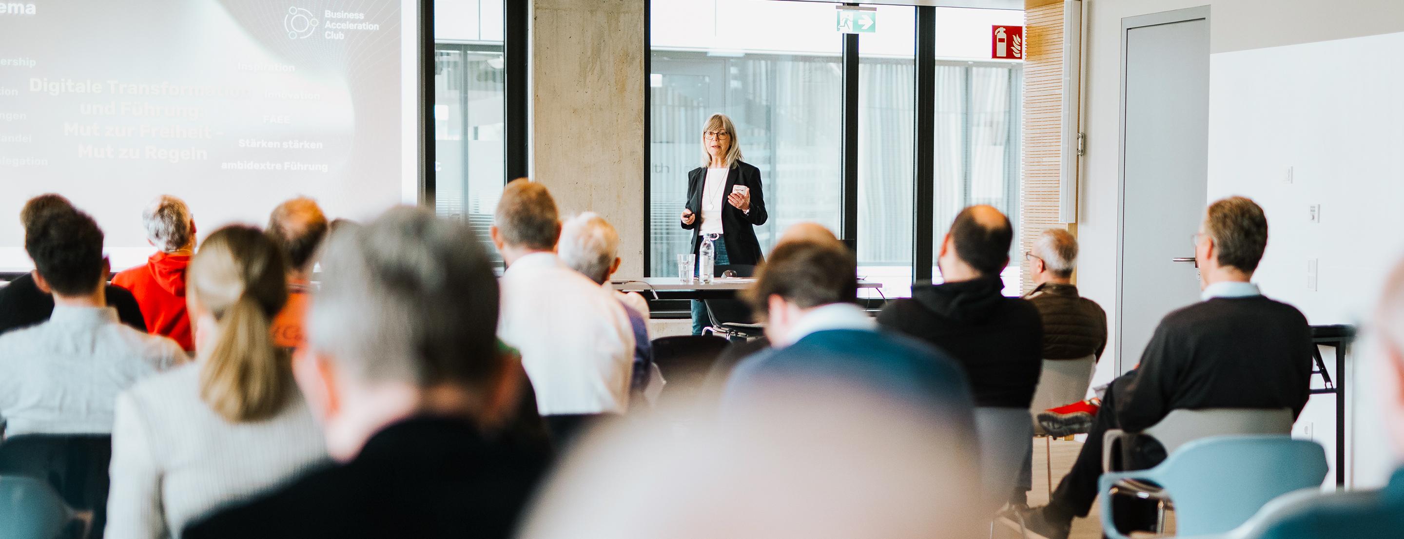 Konferenz-Situation, Dagmar spricht vor Publikum