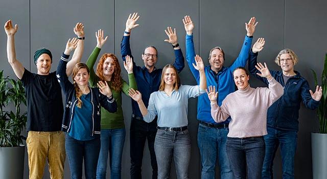 Mitarbeiter jubeln mit erhobenen Händen über die B Corp Zertifizierung